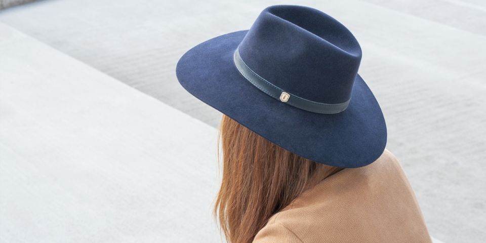 BeWooden - A woman with red hair wearing dark blue hat, brown coat and white shirt.