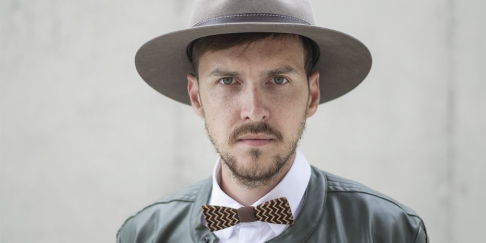 BeWooden - A man wearing brown hat with wooden detail, leather jacket and wooden bow tie.