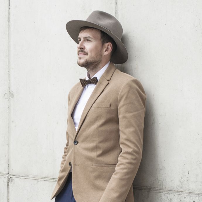 A man wearing the brown Apis hat and a brown jacket