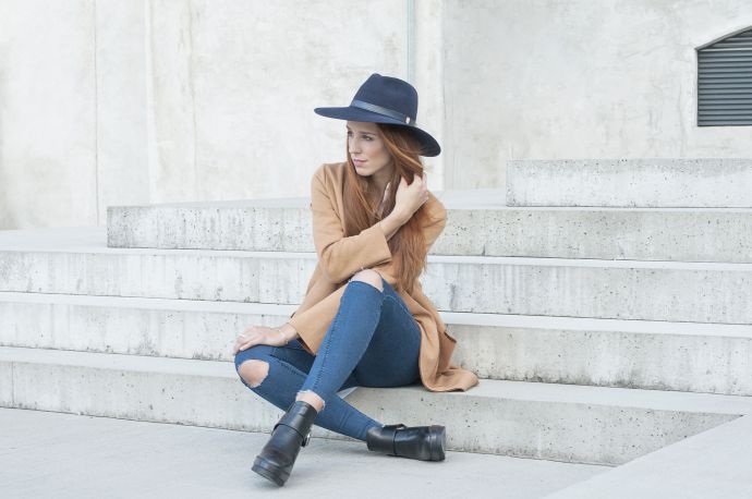 A woman wearing the blue Stellia hat, jeans and a brown coat