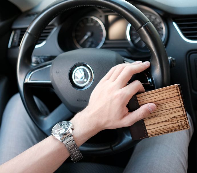 A man behind the wheel with the Nox Virilia wooden wallet