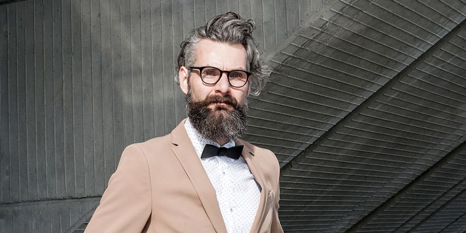 A man in a brown coat with the wooden bow tie Eguus A man in a brown coat with the wooden bow tie Eguus