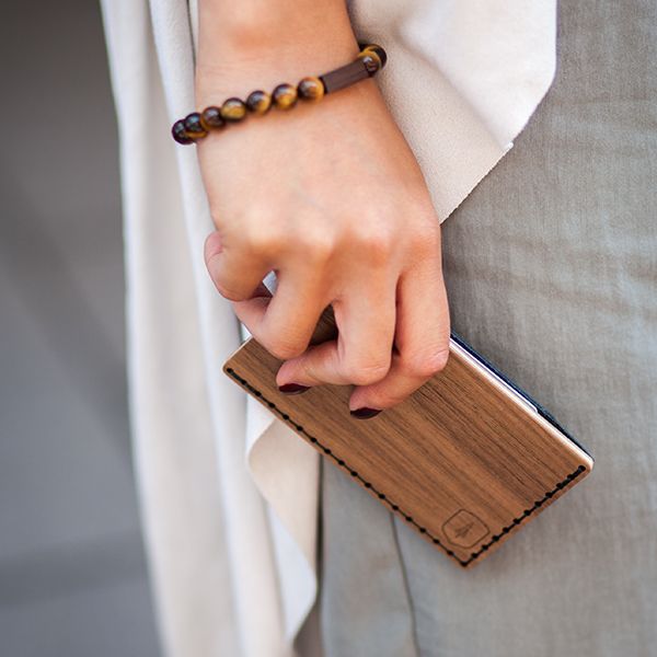 A woman with the wooden cardholder Nox Note in hand