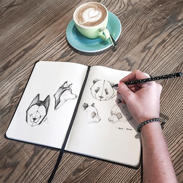 A woman in a café writes in the BeWooden notebook