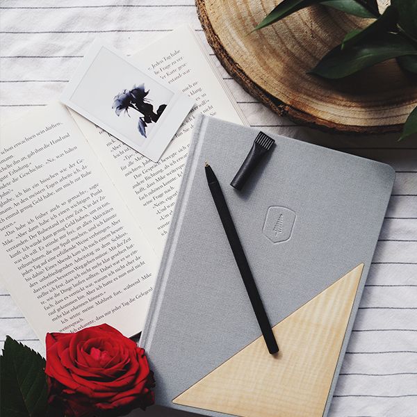 A notebook lies next to a book