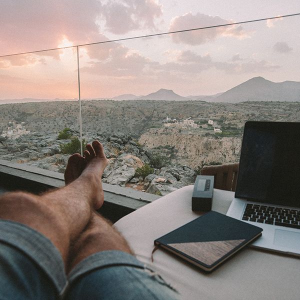 A man sits by the window with the Ocean notebook next to him