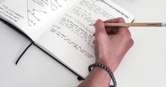 A woman wearing the Silver Hematit bracelet writes in the notebook